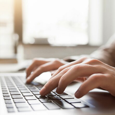 Fingers tapping on a laptop keyboard