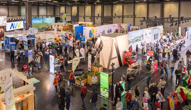 Messehalle mit vielen Besuchern und bunten Ständen