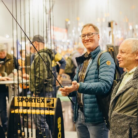 Besucher schauen sich verschiedene Angeln an