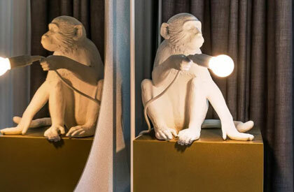 Eine Affenstatue hält eine angeschaltete Lampe
